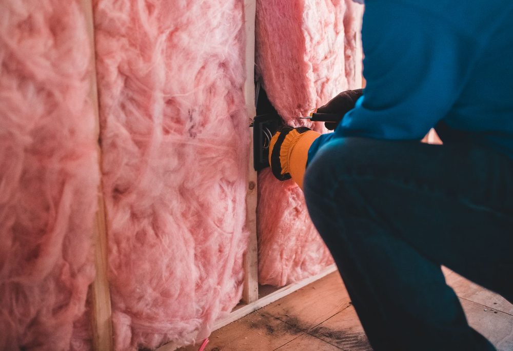 Mineral wool insulation being fitted between wall studs to reduce cavity resonance